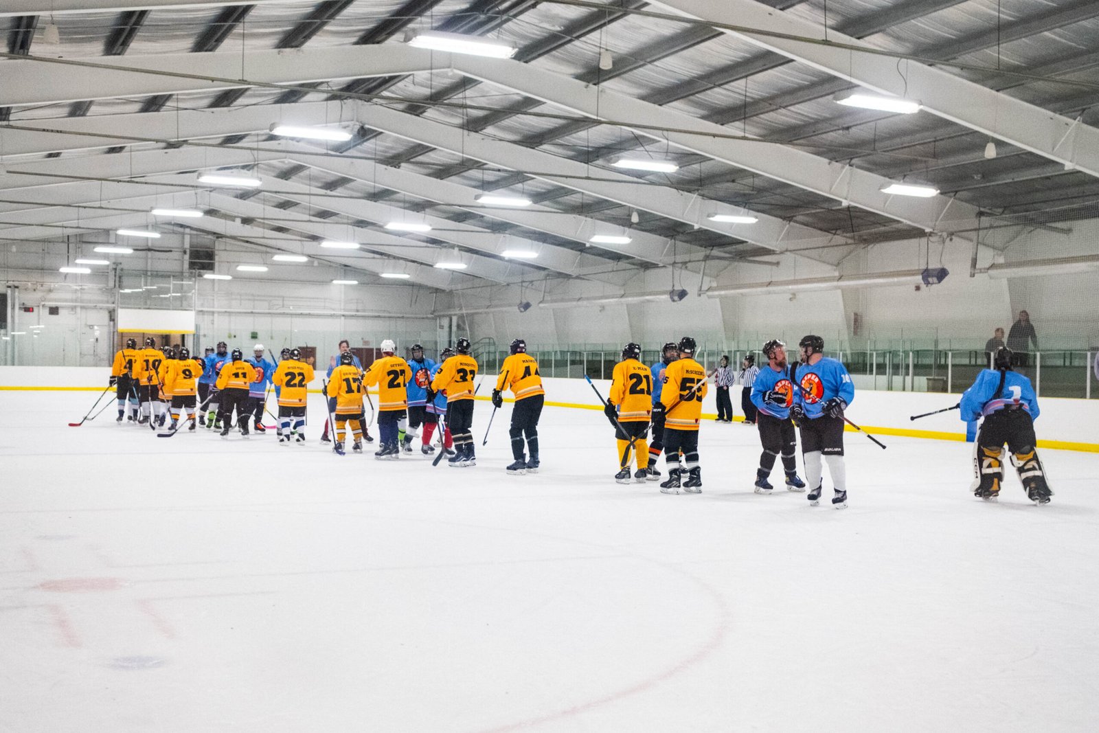 Players shaking hands after a game in the Shinny of Champions August Beginner Tournament